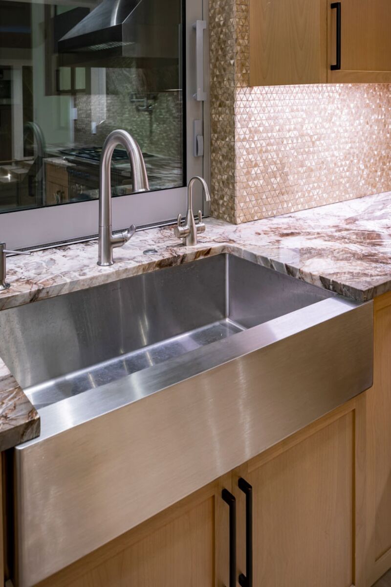 Inset stainless steel farmhouse style sink with granite countertops